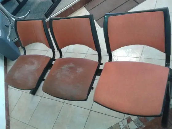 Čistenie sedadiel v Bratislave: tri oranžové sedadlá na čiernom stojane, dve ľavé majú svetlé stopy na sedáku