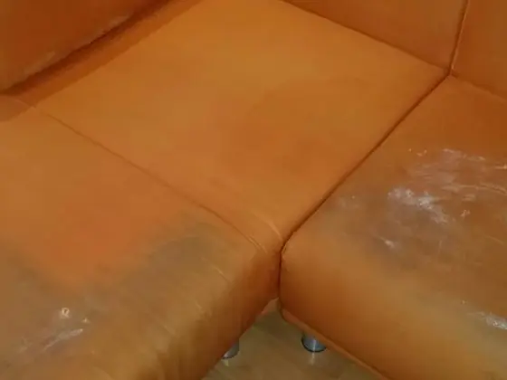 Čistenie rohovej sedačky pred tepovaním: oranžová látka s tmavými zónami a bielymi stopami na sedákoch