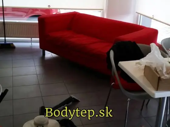 Tepovanie sedačky v Bratislave: červená dvojsedačka na dlaždiciach, v popredí stojí tepovací stroj s hadicou