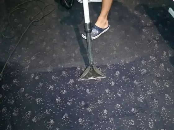 Tepovanie tmavého koberca v Bratislave, hubica na vzorovanom koberci a viditeľná hranica medzi tmavším a svetlejším pásom