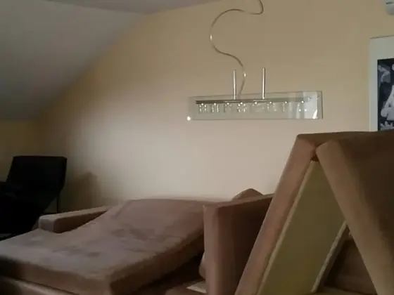 Tepovanie rozloženej sedacej súpravy v hnedej látke, sedáky a opierky odložené na podkroví pod šikmým stropom