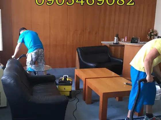 Čistenie čalúneného nábytku v kancelárii v Bratislave, čierna kožená sedačka a dvaja pracovníci