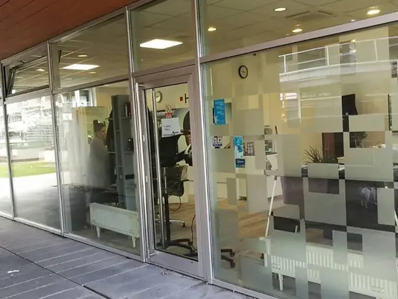 Umývanie výkladov: presklený vchod do kancelárie s matným vzorom na skle a dlažbou pred ním