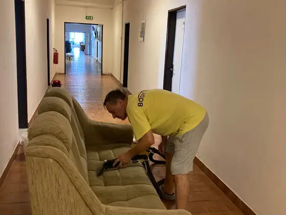 Tepovanie sedačky na chodbe: zelená sedačka s hubicou a dlhá chodba s dlažbou v Bratislave