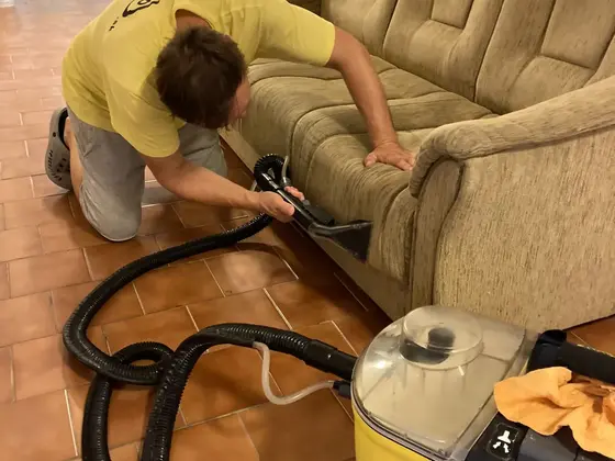 Tepovanie pohovky: technik s hubicou pri trojsedačke a tepovací stroj na dlažbe