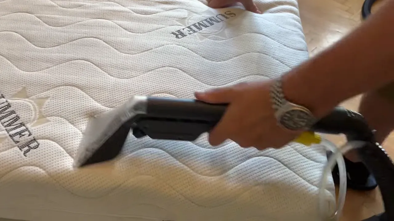 Video: ručná hubica tepovača prechádza po bielom prešívanom poťahu matraca