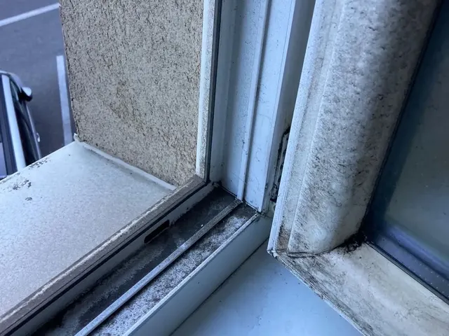 Detail rohu okna s otvoreným krídlom, rám a drážky plné prachu a nečistôt