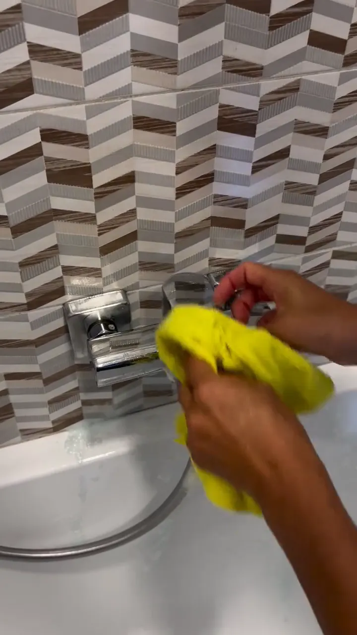 Video: ruka so žltou handrou utiera chrómovú vaňovú batériu a potom sprchovú hlavicu